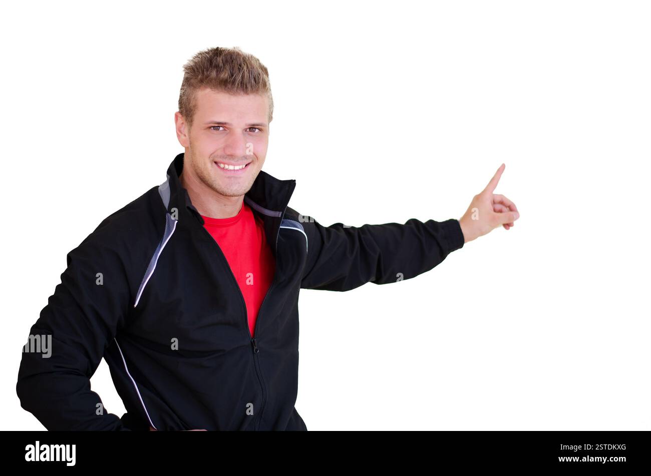 Giovane personal trainer sorridente che punta il dito nello spazio vuoto Foto Stock