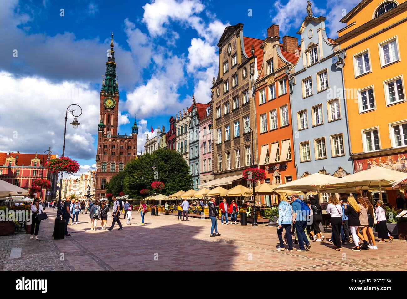 Vista del centro storico di Danzica, nella Polonia settentrionale. Una piazza, il municipio, edifici alti colorati e gente che cammina durante la bella giornata. Foto Stock
