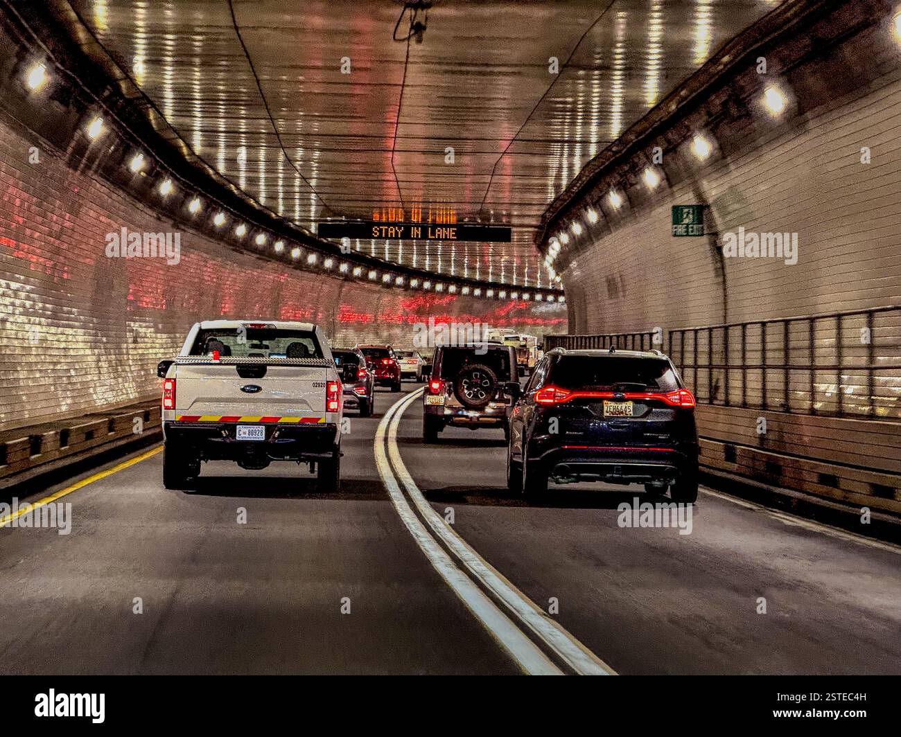 Le auto attraversano un tunnel a doppia corsia Foto Stock
