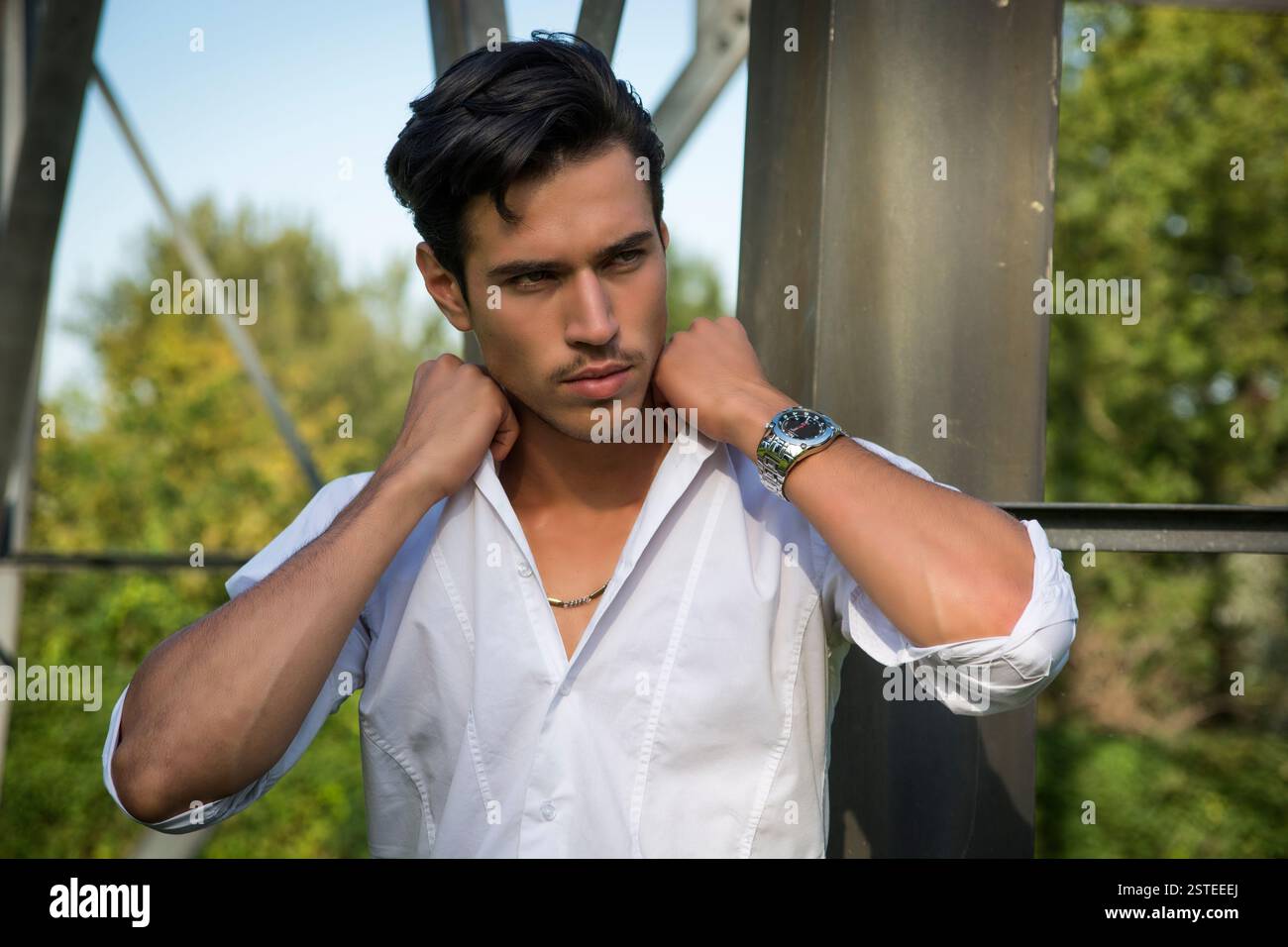 Bel giovane appoggiata contro il metallo trellis di elettricità Foto Stock