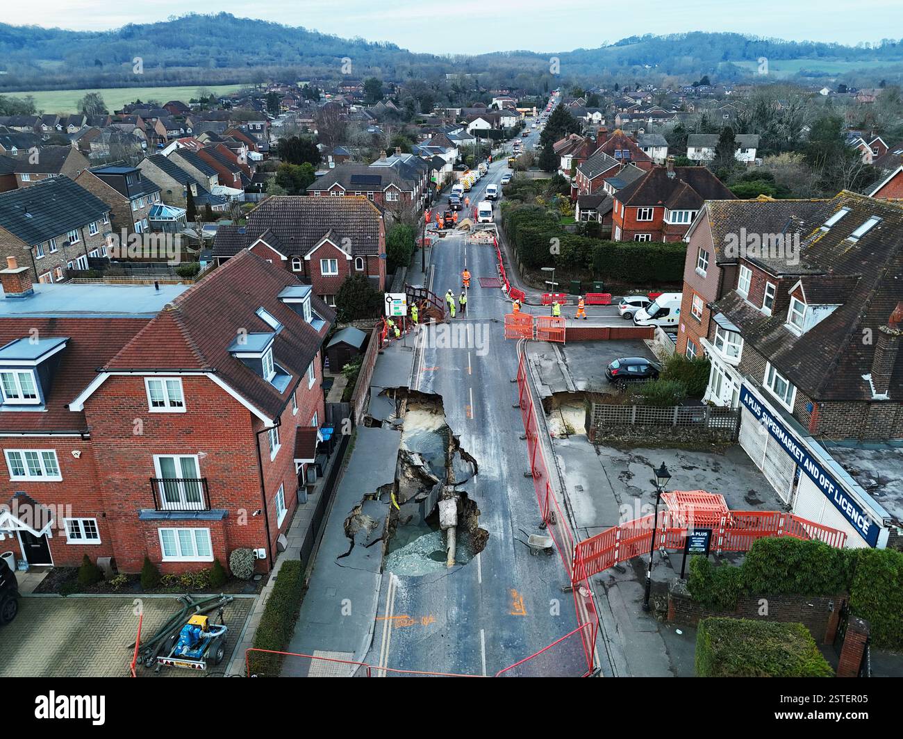La scena di Godstone dopo una dolina è apparsa lunedì sera. La grande dolina ha forzato la chiusura della strada principale nel villaggio del Surrey. La polizia del Surrey ha detto martedì che Godstone High Street era chiusa tra Oxted Road e Bletchingley Road. La forza aggiunse che un piccolo numero di edifici furono evacuati come precauzione e che fu messo in atto un cordone di 100 metri. Data foto: Martedì 18 febbraio 2025. Foto Stock