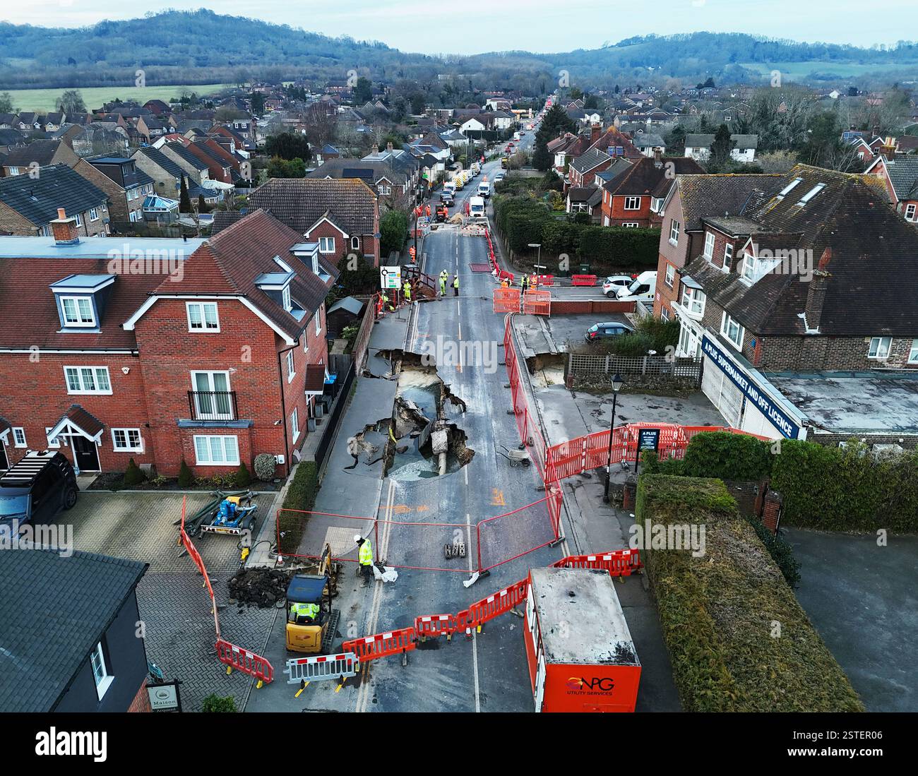 La scena di Godstone dopo una dolina è apparsa lunedì sera. La grande dolina ha forzato la chiusura della strada principale nel villaggio del Surrey. La polizia del Surrey ha detto martedì che Godstone High Street era chiusa tra Oxted Road e Bletchingley Road. La forza aggiunse che un piccolo numero di edifici furono evacuati come precauzione e che fu messo in atto un cordone di 100 metri. Data foto: Martedì 18 febbraio 2025. Foto Stock