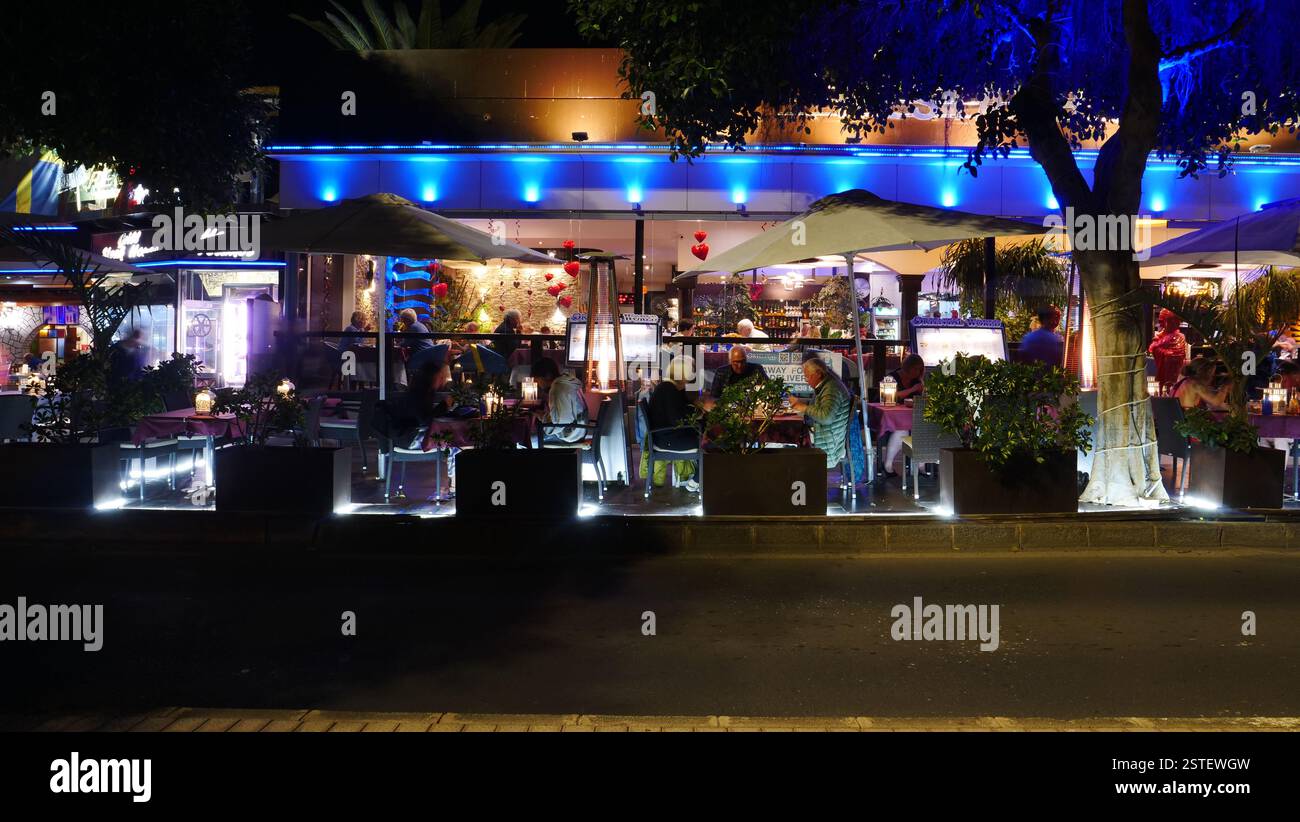 Foto serali di ristoranti sulla strada del lungomare in Avenue de las Playas, Puerto del Carmen. Foto Stock