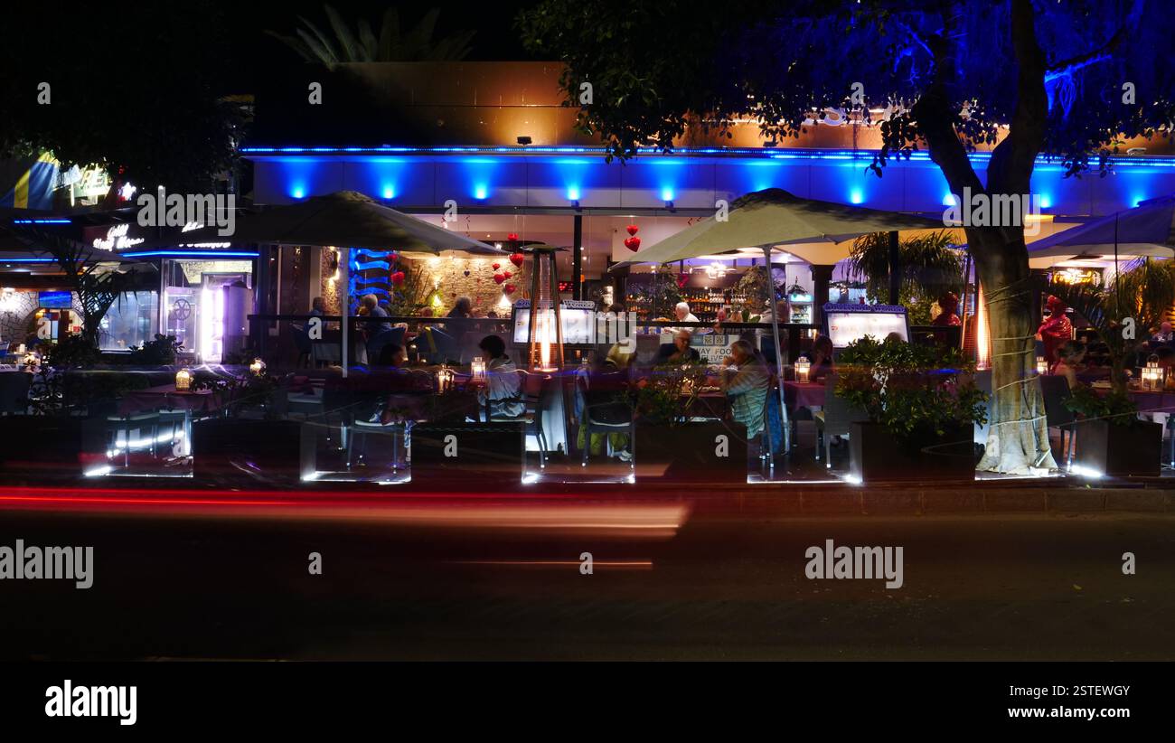 Foto serali di ristoranti sulla strada del lungomare in Avenue de las Playas, Puerto del Carmen. Foto Stock