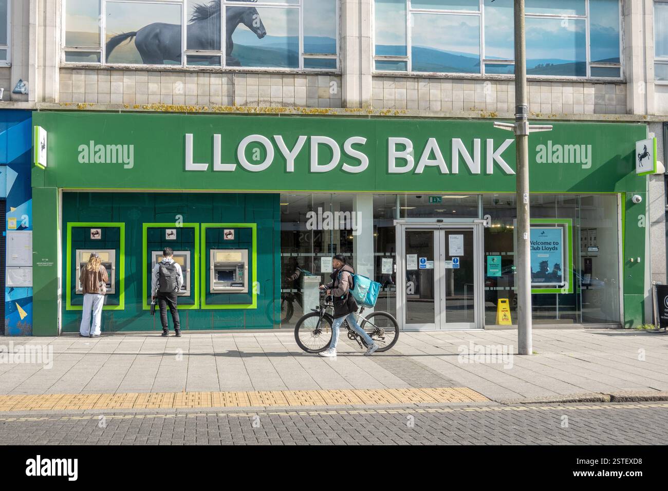 Clienti che utilizzano sportelli automatici esterni presso la filiale di Lloyds a Southampton, Inghilterra, Regno Unito Foto Stock