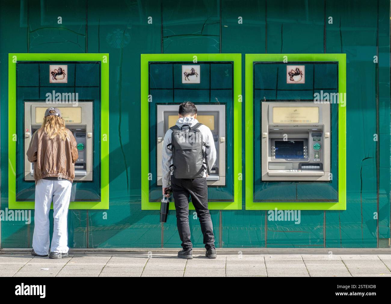 Clienti che utilizzano sportelli automatici esterni presso la filiale di Lloyds a Southampton, Inghilterra, Regno Unito Foto Stock