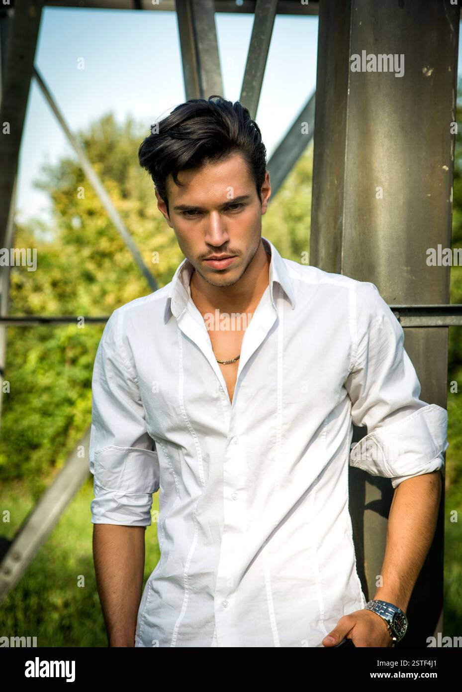 Bel giovane appoggiata contro il metallo trellis di elettricità Foto Stock