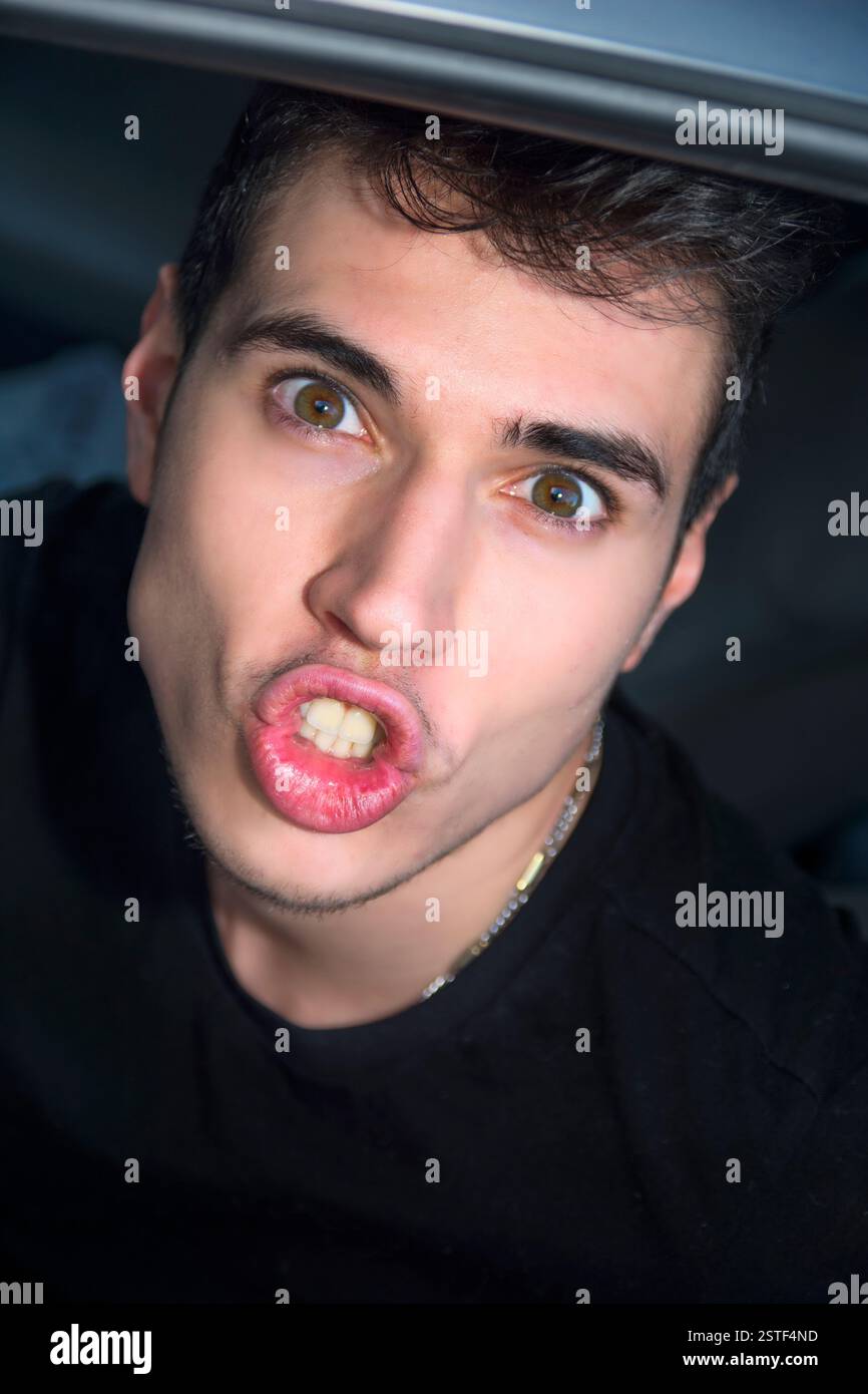 Funny giovane uomo faccia broncio con labbra e occhi grandi Foto Stock