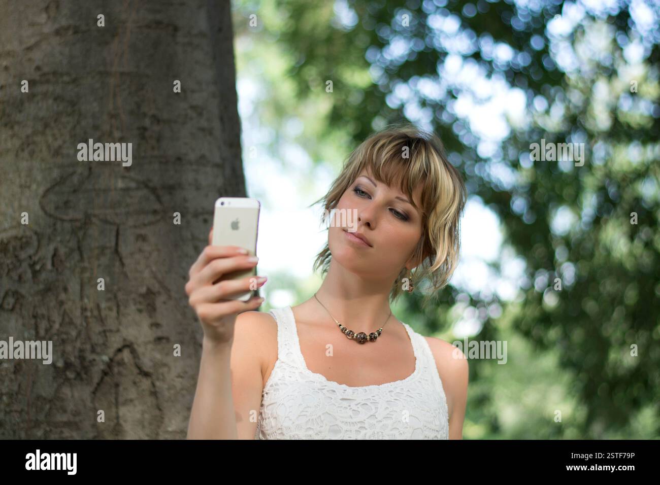 Giovane donna all'aperto prendendo foto o selfie con un telefono cellulare la telecamera Foto Stock