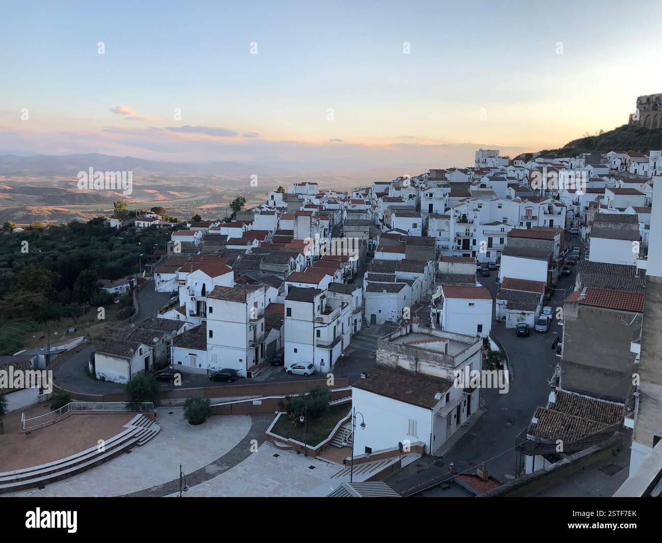 Pisticci (Matera): Vista panoramica di un villaggio collinare al tramonto che mostra case bianche e tranquillità rurale Foto Stock