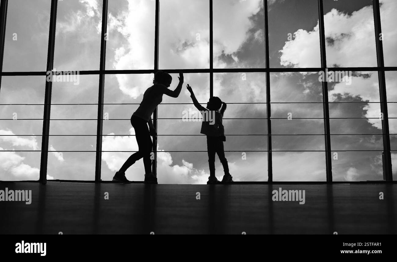 Silhouette di madre e figlia in palestra Foto Stock