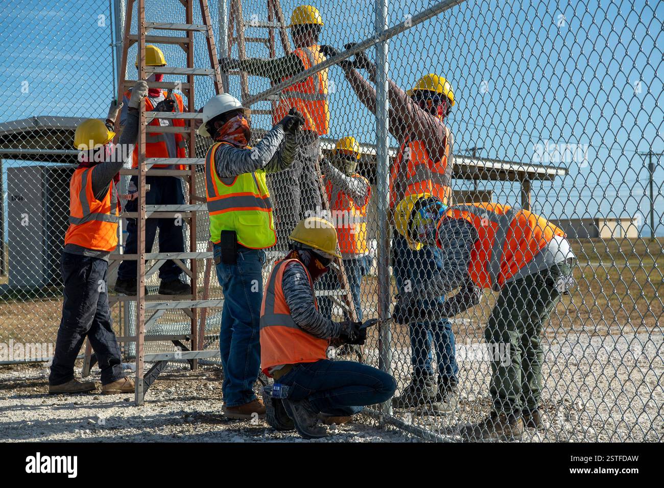 Guantánamo Bay, Cuba. 15 febbraio 2025. Gli appaltatori del Dipartimento della difesa degli Stati Uniti installano una recinzione per espandere il Centro operativo illegale di Alien Holding presso la stazione navale di Guantanamo Bay, 15 febbraio 2025 a Guantanamo Bay, Cuba. Homeland Security ha ordinato l'espansione per trattenere i migranti deportati fino a quando un altro paese non li riceverà. Crediti: PO1 Bryan mai/U. S Navy Photo/Alamy Live News Foto Stock