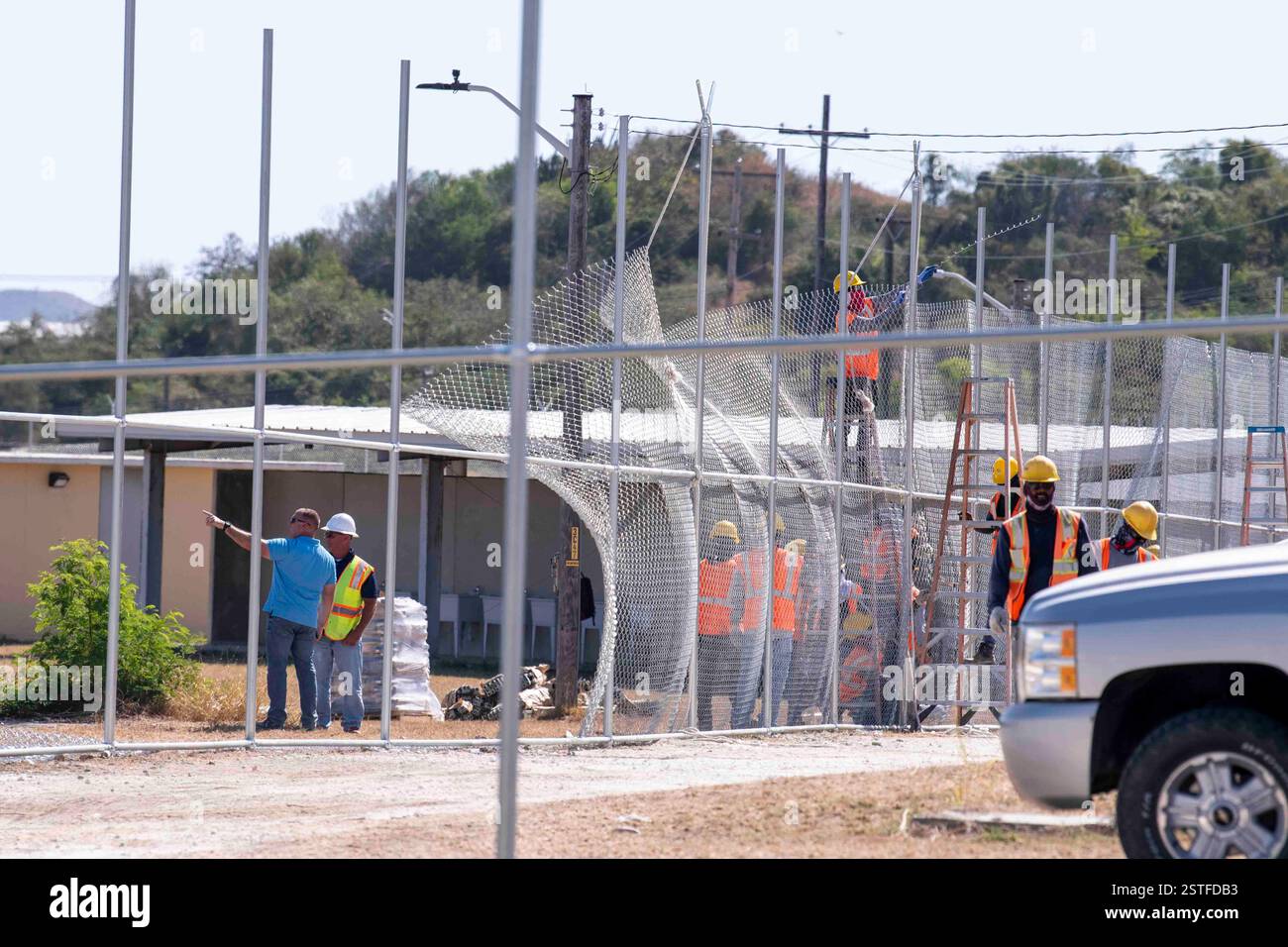Guantánamo Bay, Cuba. 16 febbraio 2025. Gli appaltatori del Dipartimento della difesa degli Stati Uniti installano una recinzione per espandere il Centro operativo illegale Alien Holding presso la stazione navale di Guantanamo Bay, 16 febbraio 2025 a Guantanamo Bay, Cuba. Homeland Security ha ordinato l'espansione per trattenere i migranti deportati fino a quando un altro paese non li riceverà. Crediti: PO2 Mason Congleton/U. S Navy Photo/Alamy Live News Foto Stock