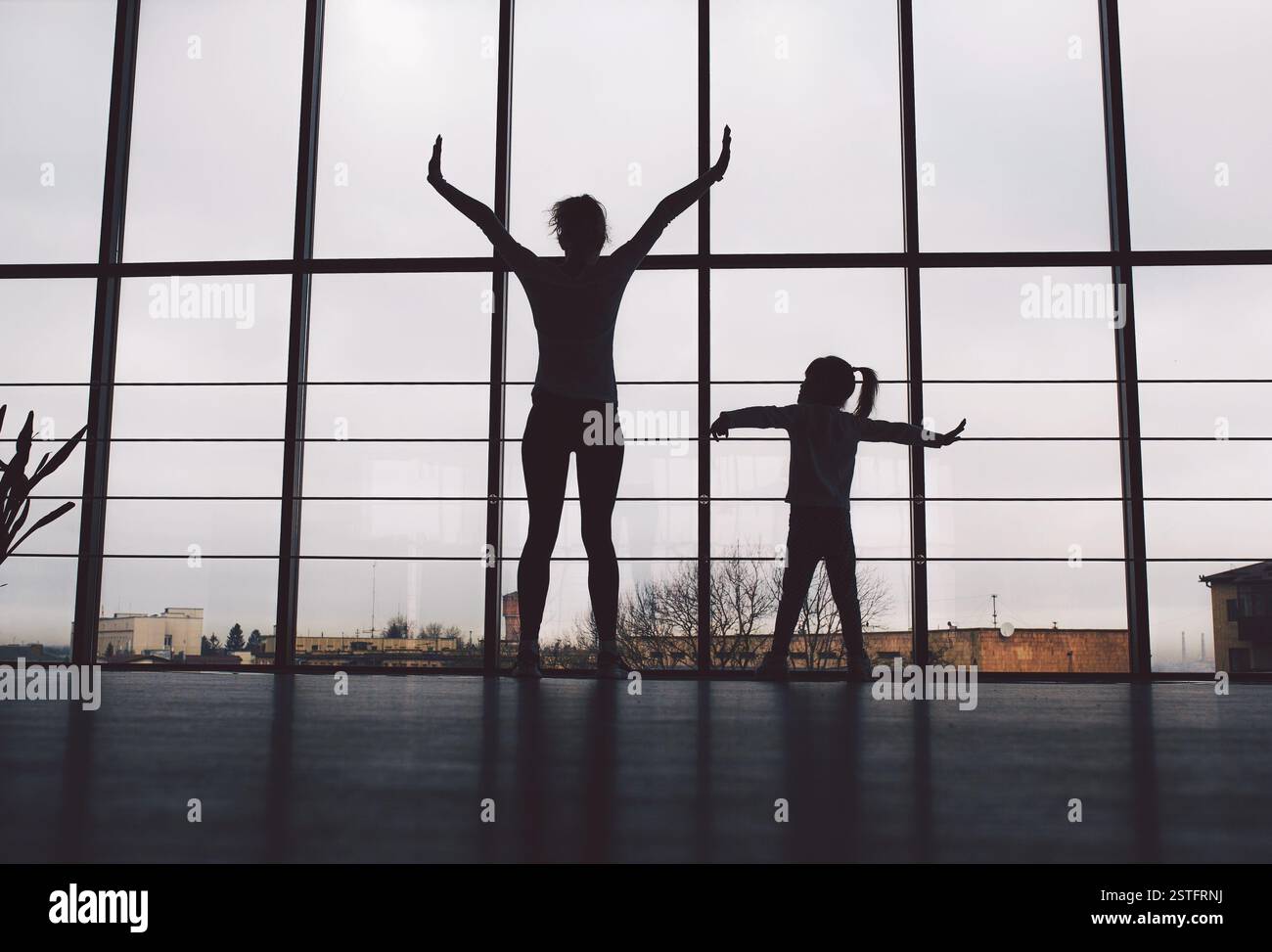 Silhouette di madre e figlia in palestra Foto Stock