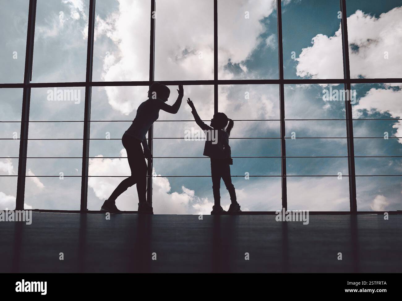 Silhouette di madre e figlia in palestra Foto Stock