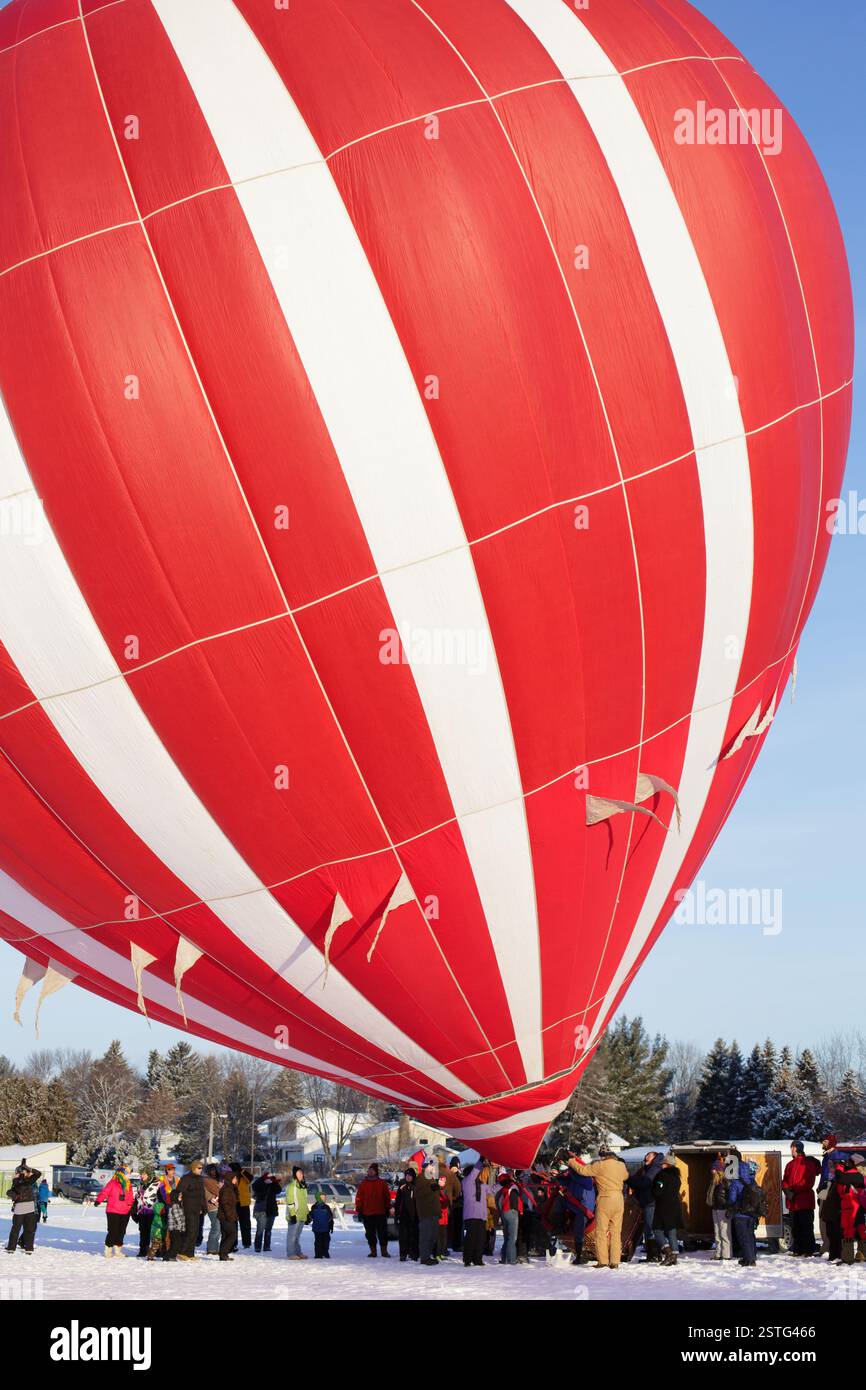 Mongolfiera rossa gonfiata in occasione di un festival invernale. Foto Stock