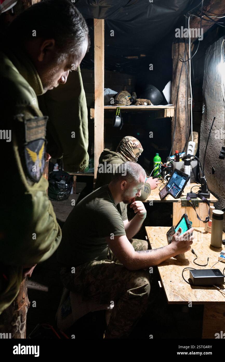 Ucraina. 22 dicembre 2024. All'interno di un bunker sotterraneo, gli operatori di droni ucraini volano un drone per colpire le posizioni russe in prima linea. La guerra tra Ucraina e Russia ha dimostrato quanto i droni economici e sacrificabili, come il kamikaze o i modelli che lanciano bombe, stiano rimodellando la guerra. Questi droni consentono attacchi precisi e a basso costo e si sono dimostrati estremamente efficaci nell'interrompere le operazioni nemiche. Di conseguenza, stanno cambiando le strategie militari, segnalando un futuro in cui i droni svolgono un ruolo centrale nel combattimento, riducendo la dipendenza dalle armi tradizionali e costose. (Immagine di credito: © Miguel Cande Foto Stock