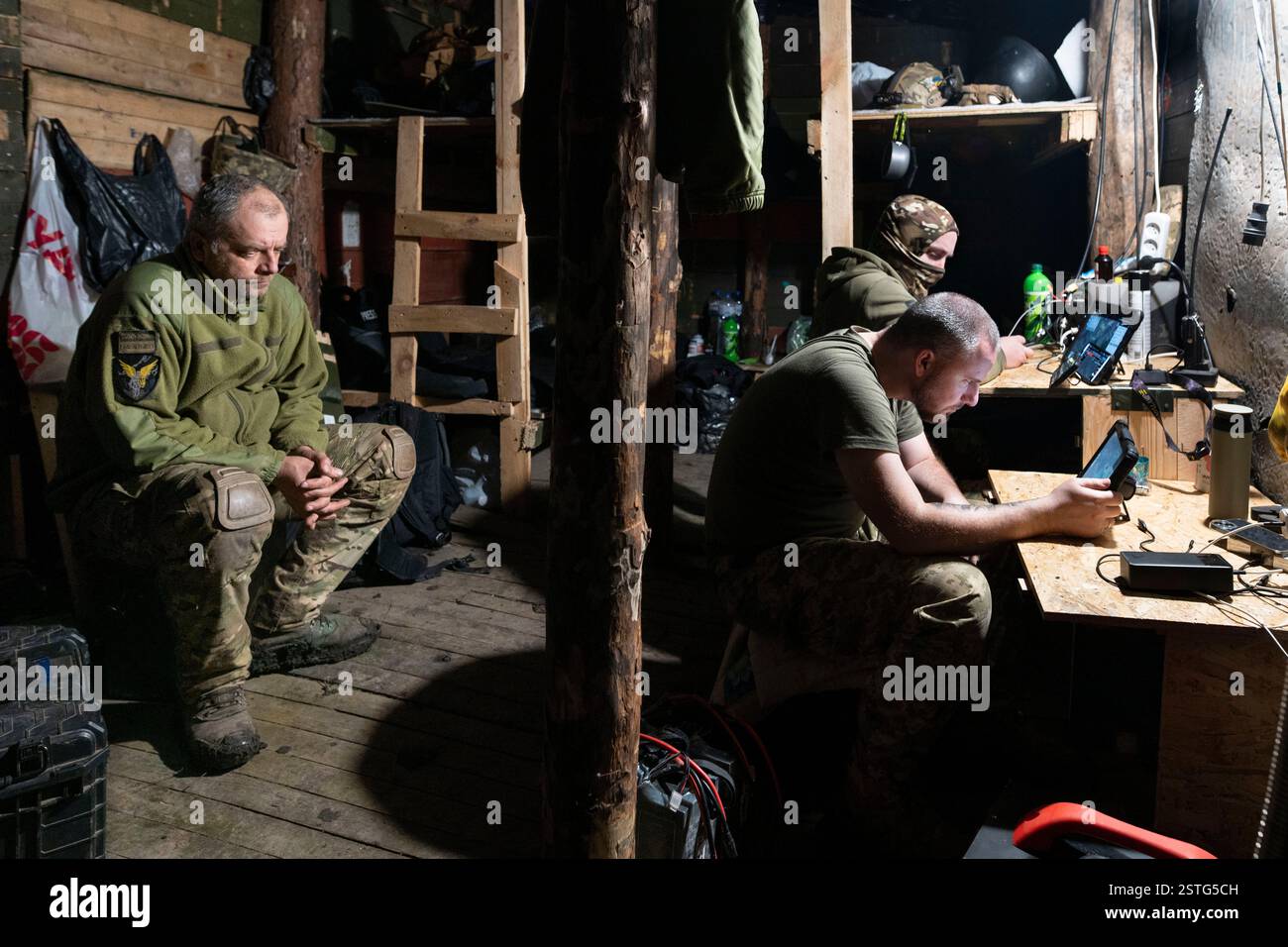 Ucraina. 22 dicembre 2024. All'interno di un bunker sotterraneo, gli operatori di droni ucraini volano un drone per colpire le posizioni russe in prima linea. La guerra tra Ucraina e Russia ha dimostrato quanto i droni economici e sacrificabili, come il kamikaze o i modelli che lanciano bombe, stiano rimodellando la guerra. Questi droni consentono attacchi precisi e a basso costo e si sono dimostrati estremamente efficaci nell'interrompere le operazioni nemiche. Di conseguenza, stanno cambiando le strategie militari, segnalando un futuro in cui i droni svolgono un ruolo centrale nel combattimento, riducendo la dipendenza dalle armi tradizionali e costose. (Immagine di credito: © Miguel Cande Foto Stock