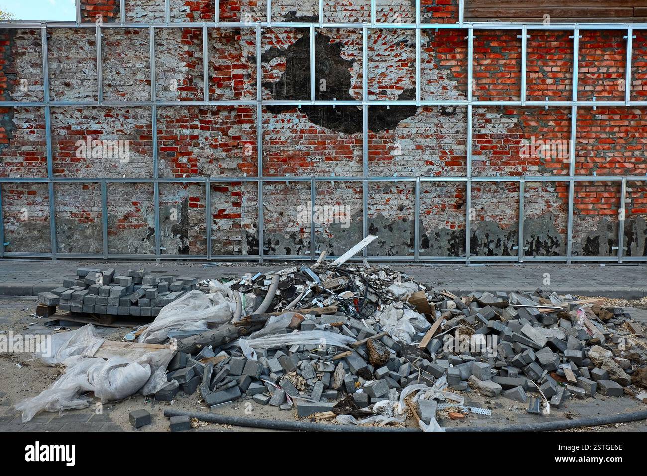 La riparazione del vecchio muro in mattoni. Montando la nuova superficie su rotaie in alluminio. Foto Stock