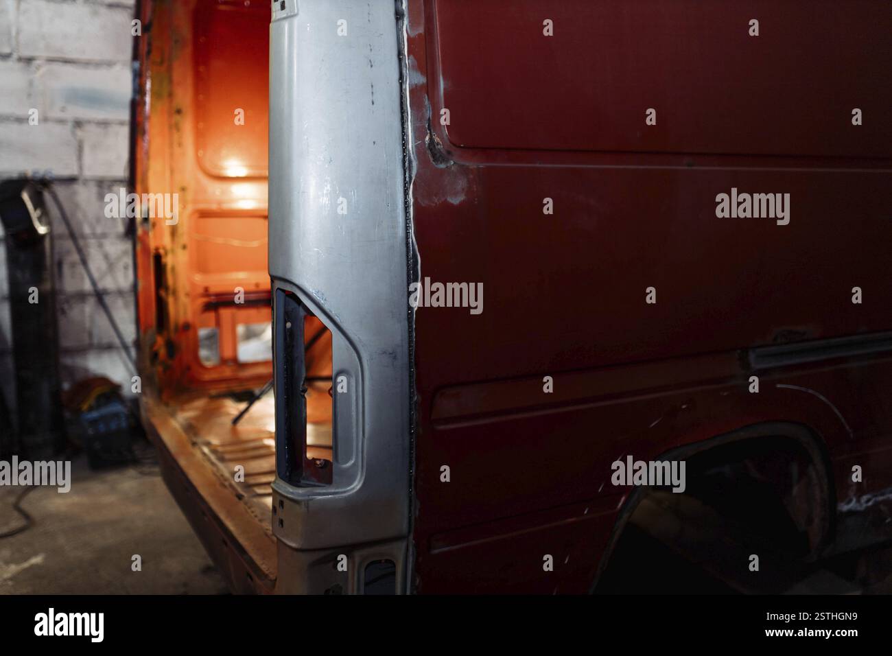 Un furgone rosso in un'officina con la portiera posteriore aperta, che rivela l'abitacolo Foto Stock