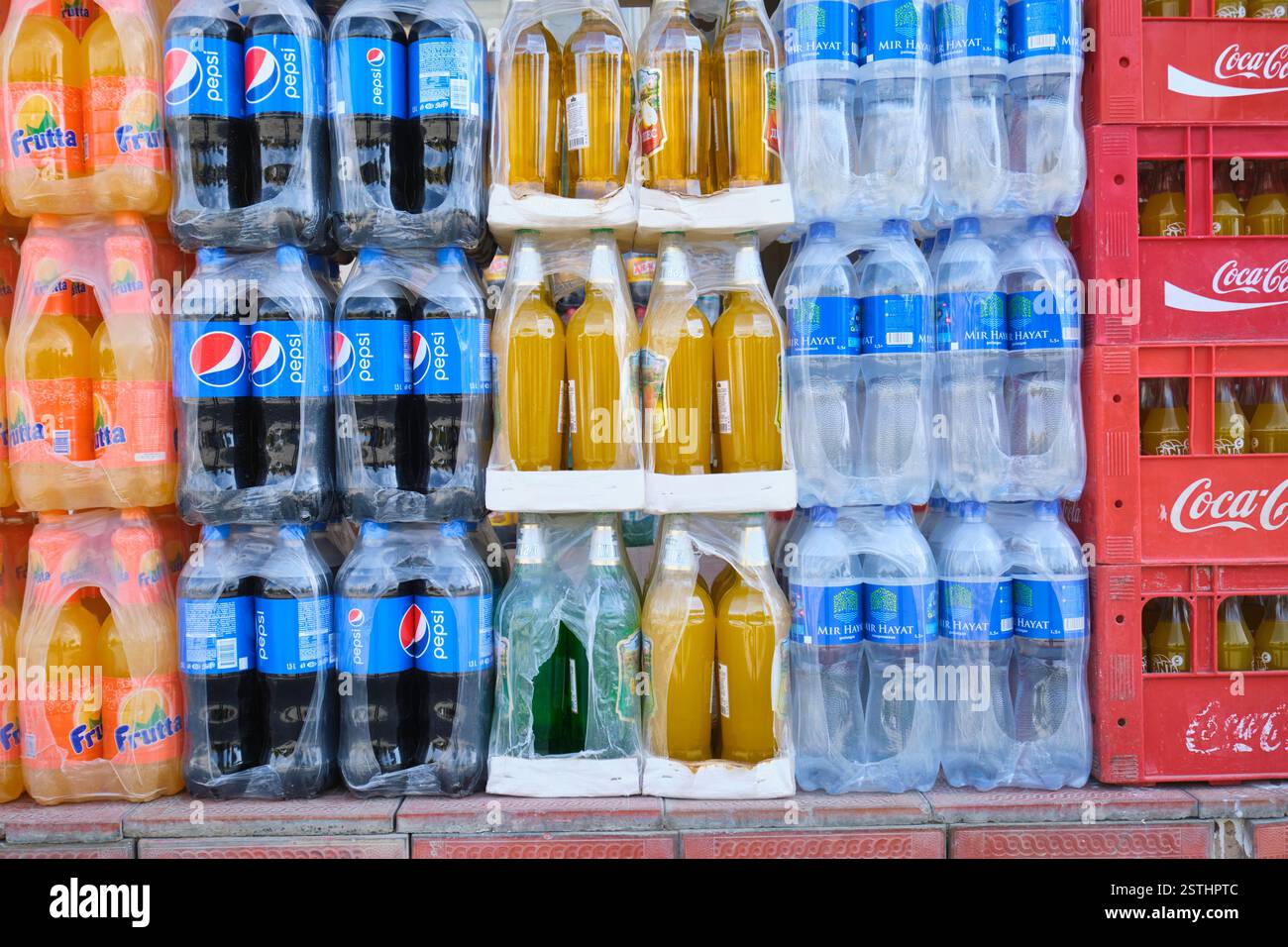 Dettaglio, primo piano di una pila di bibite analcoliche, bottiglie di plastica sodata, tra cui Pepsi, frutta, Mir Hayat Water. A Samarcanda, Uzbekistan. Foto Stock