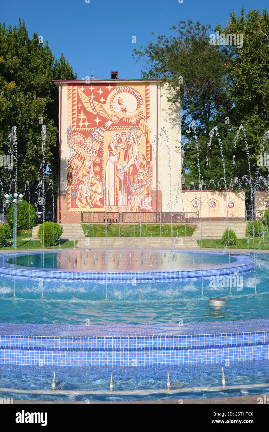 Un recente murale gigante su un edificio. Un tema uzbeko del raccolto, dell'uccello Humo, delle donne che cantano. A Samarcanda, Uzbekistan. Foto Stock