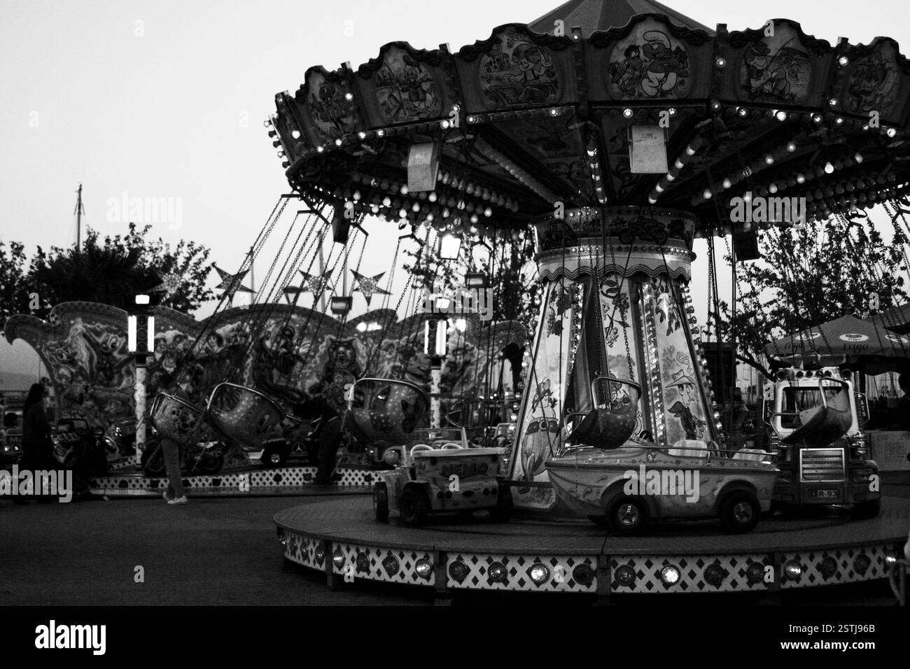 Immagine in bianco e nero di una giostra, creando un'atmosfera suggestiva e lunare. Parco divertimenti, fotografia monocromatica e un senso di nostalgia. Foto Stock