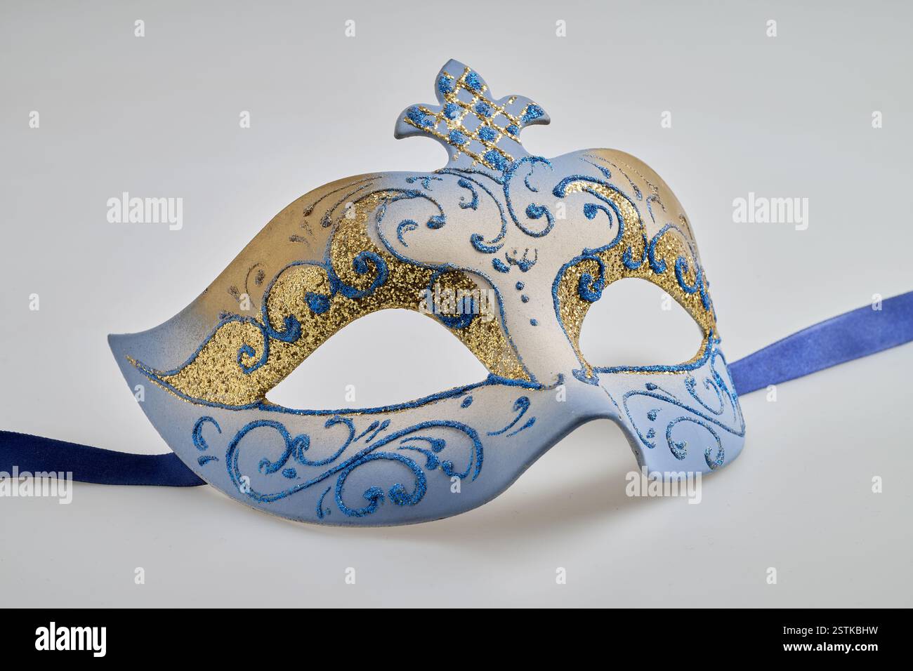 Misteriosa maschera di carnevale blu e oro su sfondo bianco Foto Stock