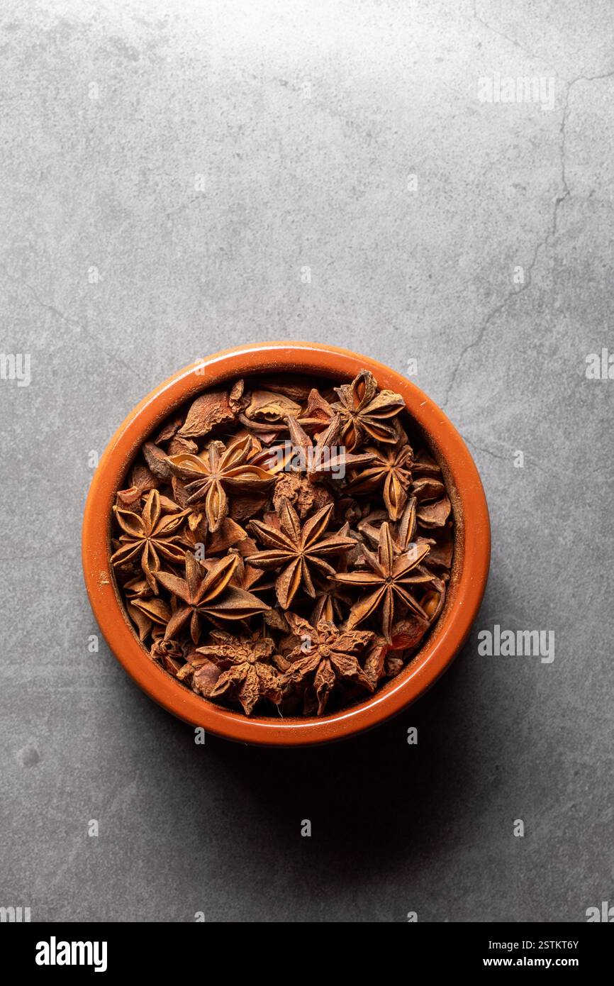 Una ciotola di argilla piena di Anis su un ripiano della cucina in una fotografia zenithal Foto Stock