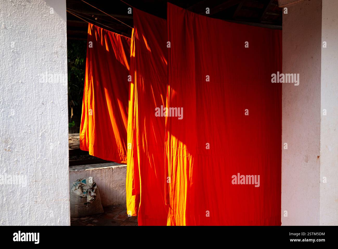 Vesti di zafferano arancioni di monaci pendono sotto il sole Foto Stock