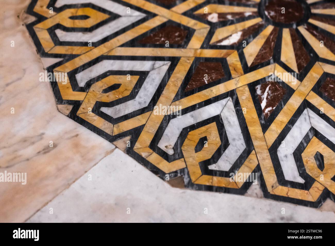 Una vista dettagliata di un design geometrico ornato realizzato con inserti in marmo, che mostra audaci motivi gialli e bianchi su una superficie liscia, perfetto per arti Foto Stock