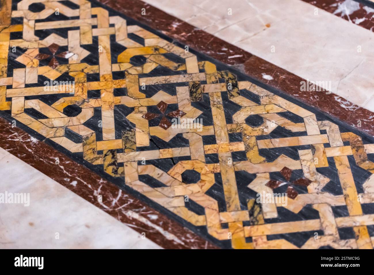 Primo piano dettagliato di un pavimento a mosaico in marmo, che mostra intricati motivi geometrici ed elementi intrecciati vibranti con pietre colorate che simboleggiano Foto Stock