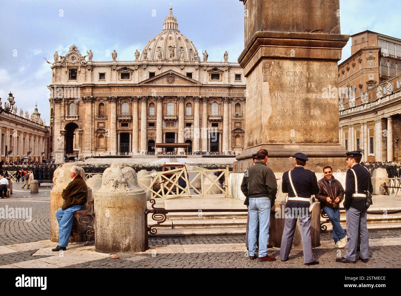 Carabinieri e gente del posto all'Obelisco Vaticano con la Chiesa di San Pietro in lontananza in Piazza San Pietro, città del Vaticano, Roma, Italia Foto Stock