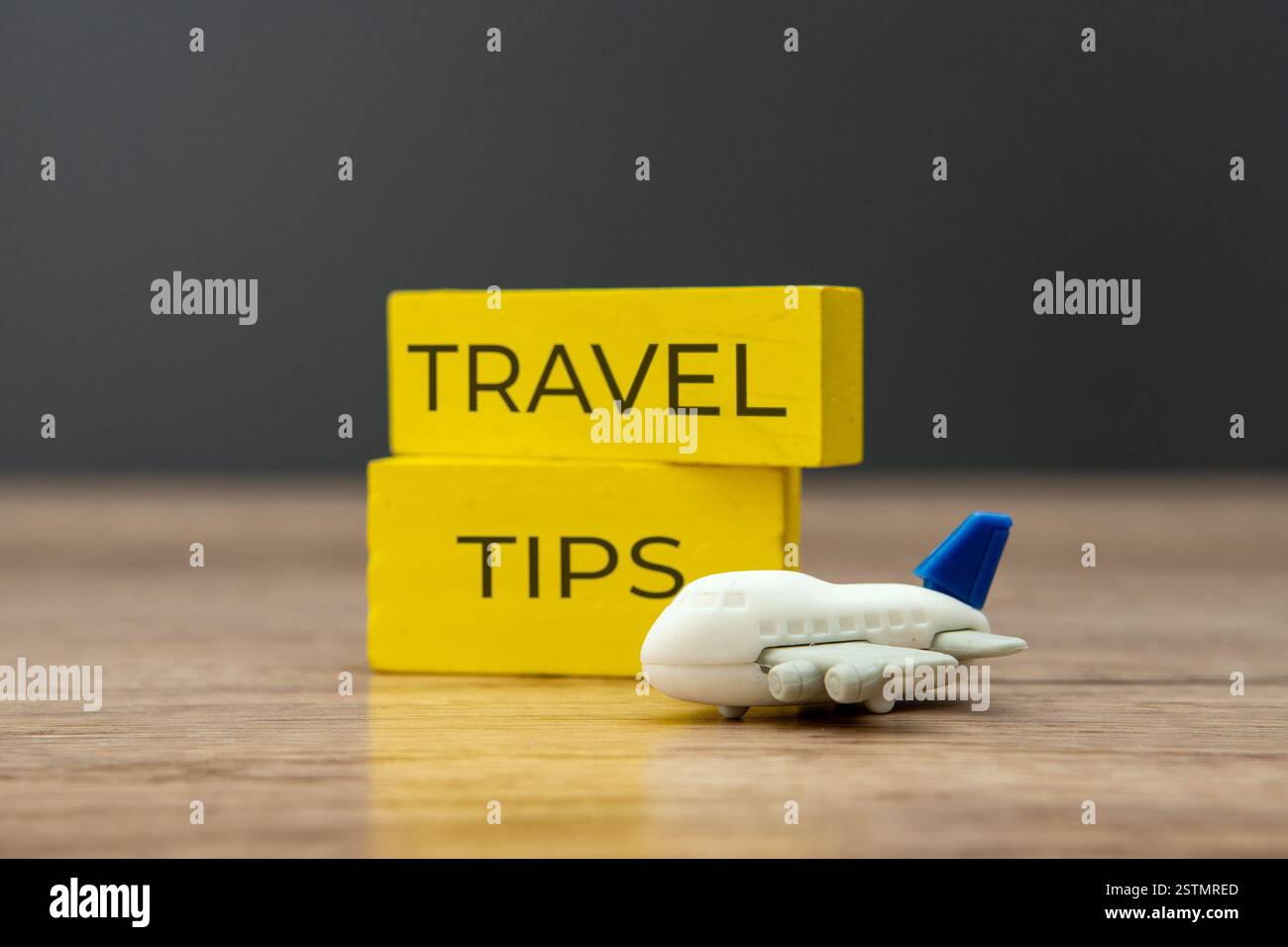 Aereo giocattolo e blocchi di legno con SUGGERIMENTI DI VIAGGIO. Concetto di viaggio e trasporto. Foto Stock