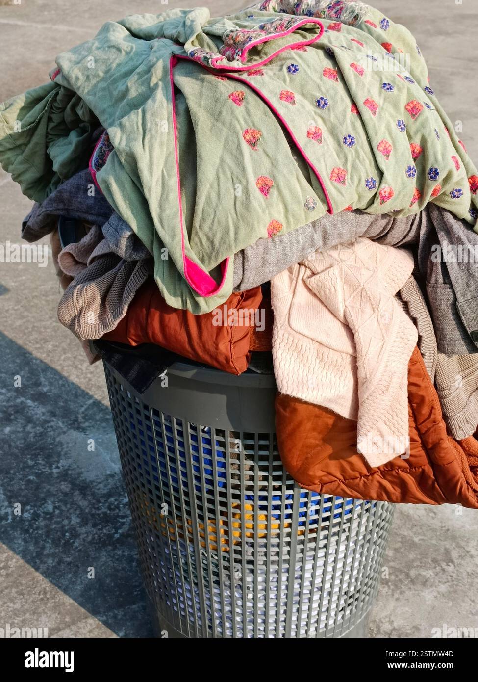 un cestino per la lavanderia pieno di vestiti pronti per il lavaggio. Foto Stock