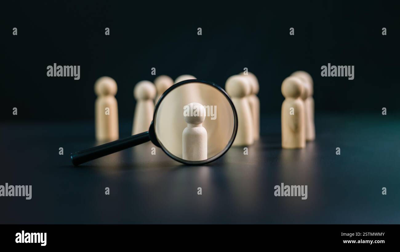 HR, HRM, concetto di reclutamento per la gestione delle risorse umane, bambola in legno e lente d'ingrandimento su sfondo scuro, concetto di lavoro di squadra, sviluppo umano re Foto Stock