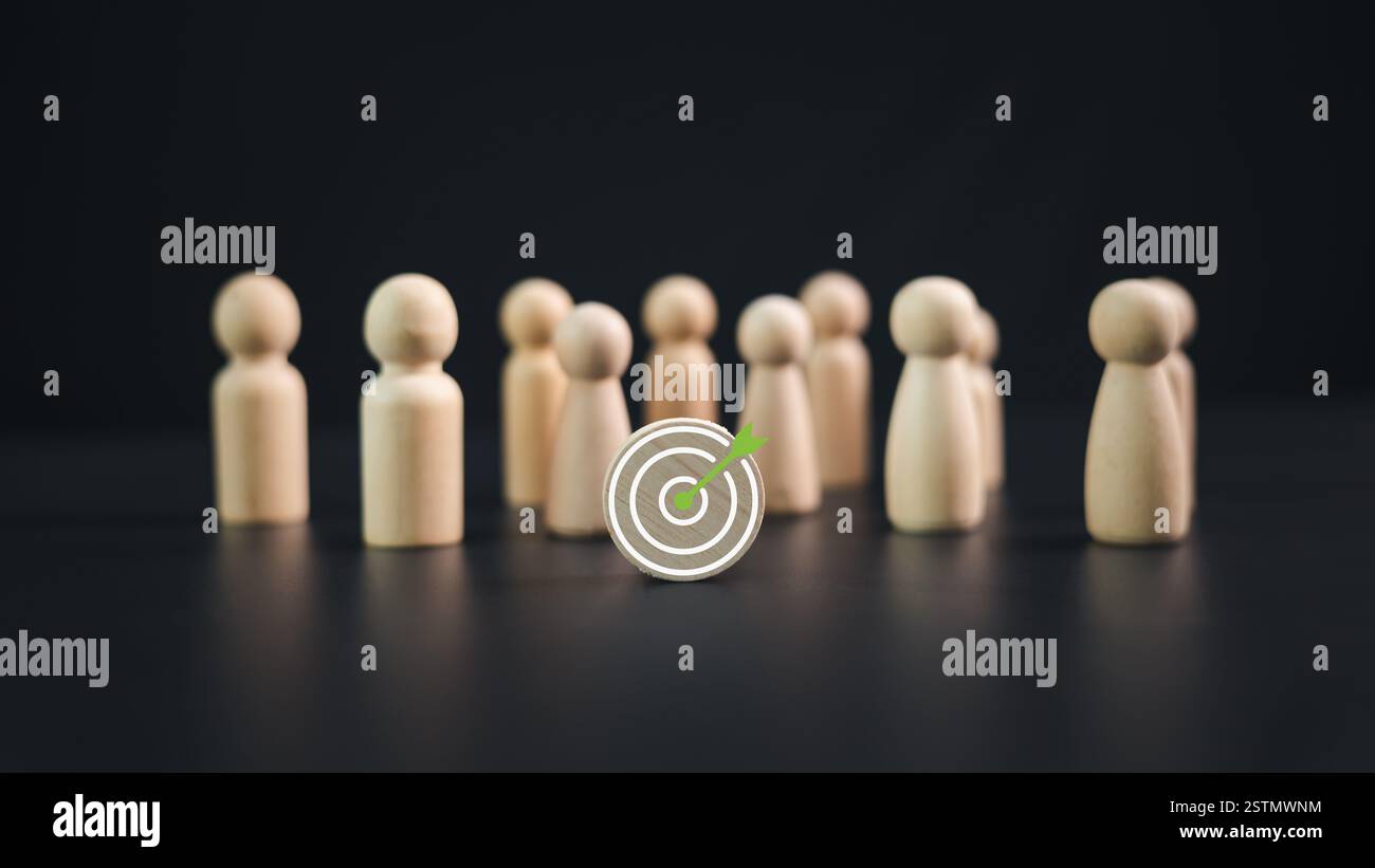 Obiettivo del team: Concetto di business e personale in un'azienda. Bambole di legno in piedi intorno al tabellone Dart e frecce per creare e indirizzare gli affari Foto Stock