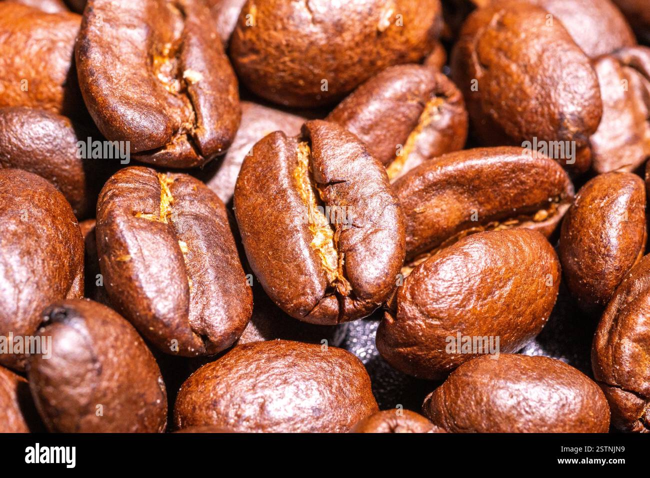 Sfondo con molti chicchi di caffè tostati, consistenza di chicchi di caffè tostati Foto Stock