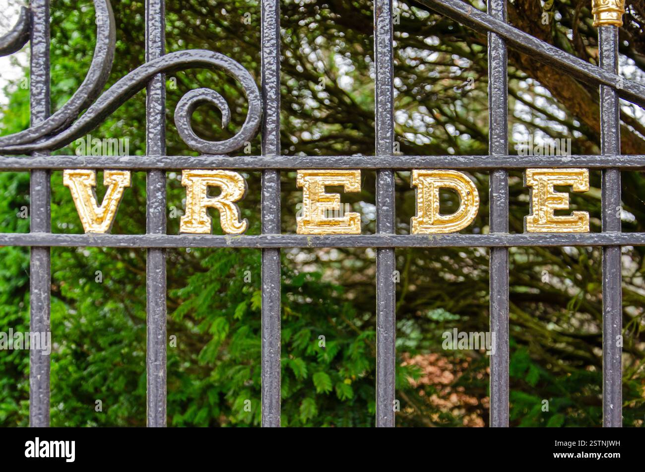 Halsteren, Paesi Bassi, 6 dicembre 2024: Recinzione del cimitero con in lettere dorate la parola "vrede" (pace) Foto Stock