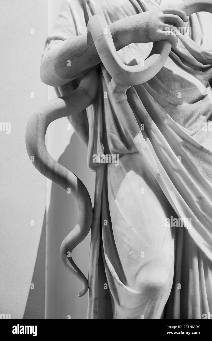 Foto in bianco e nero che mostra in dettaglio la scultura in marmo del corpo di un serpente tenuto da una mano umana Foto Stock