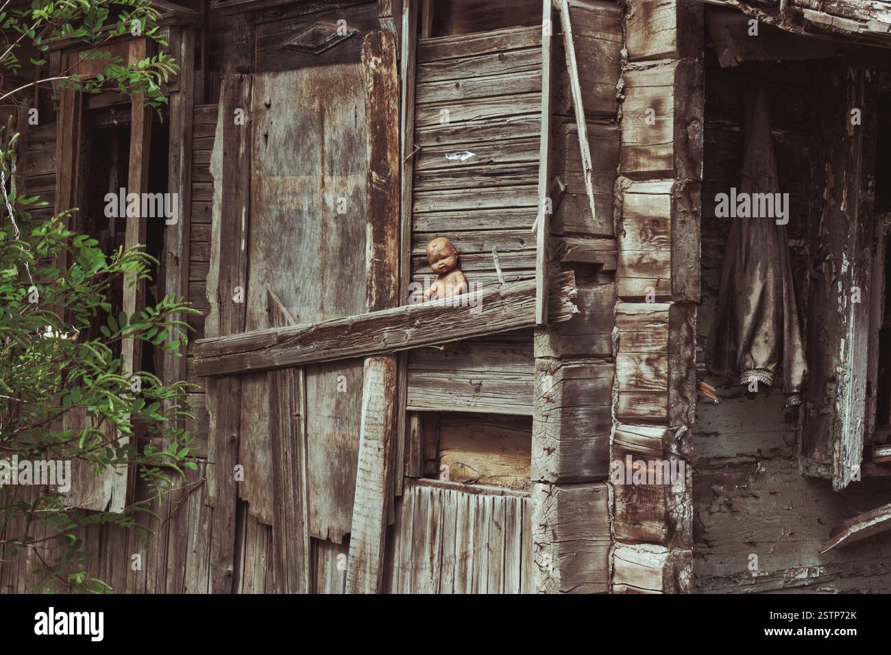 Vecchia casetta distrutta con una bambola spaventosa Foto Stock