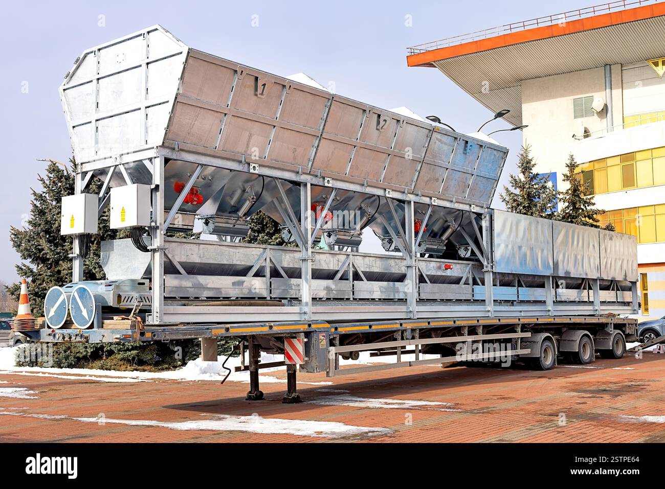 Rimorchio di trasporto grande con tramogge, vibratori e scuotitori rossi per impianti di miscelazione del calcestruzzo pronti per l'uso. Foto Stock
