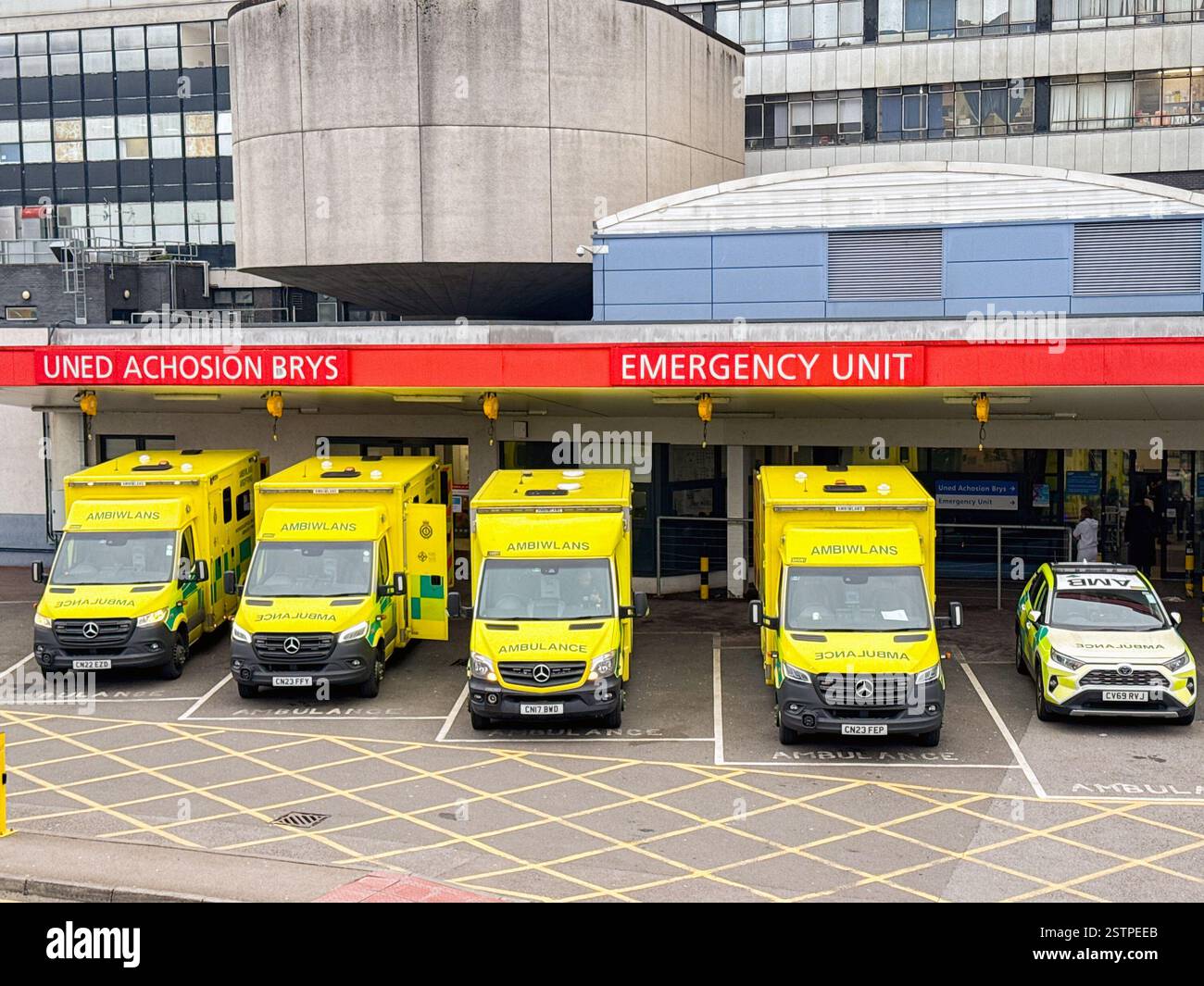 Cardiff, Galles, Regno Unito - 17 febbraio 2025: Ambulanze in attesa fuori dal pronto soccorso dell'ospedale Heath vicino al centro di Cardiff - Immagine stock catturata con smartphone