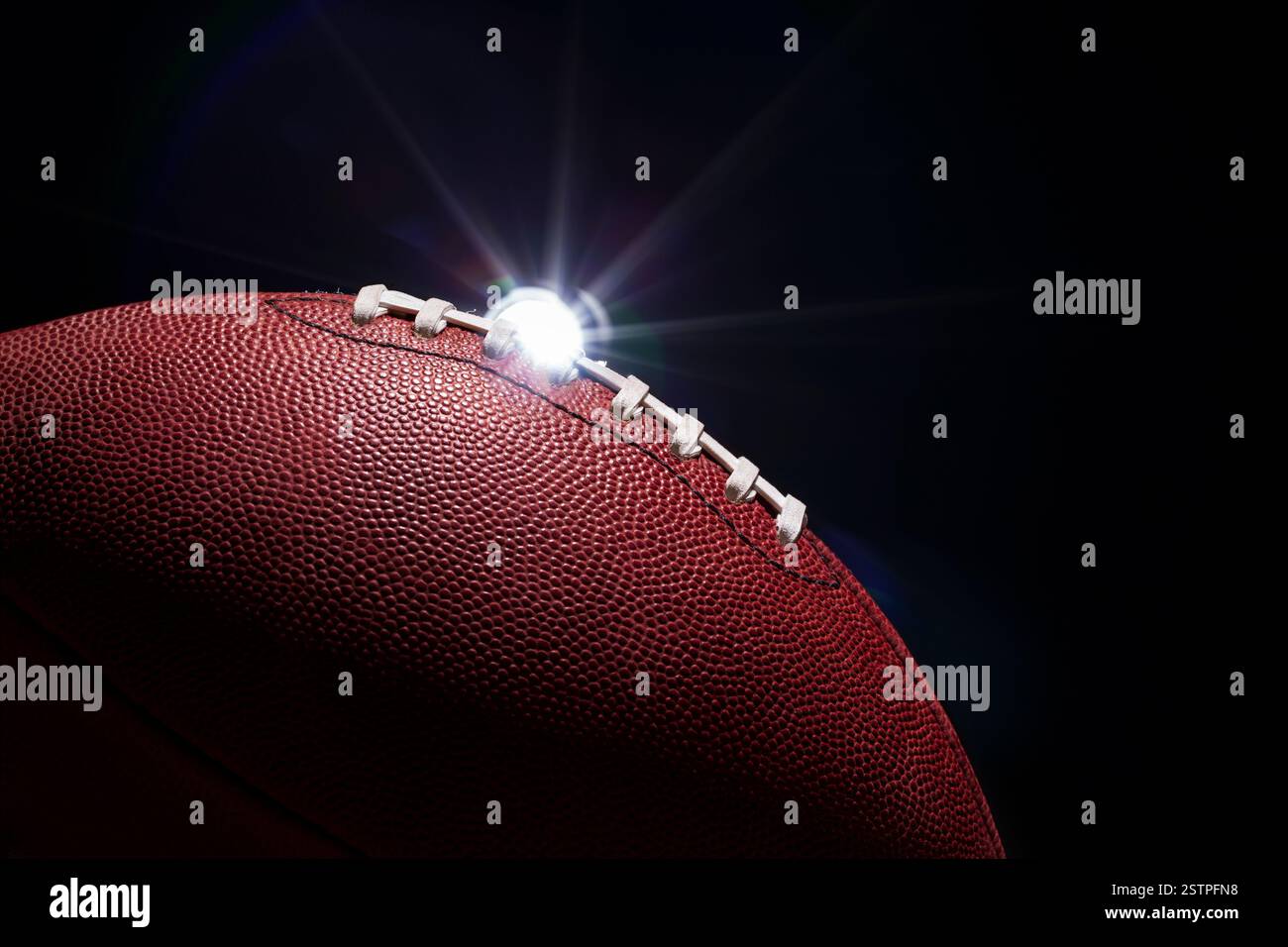 Primo piano di calcio con illuminazione spettacolare e un bagliore su sfondo nero Foto Stock