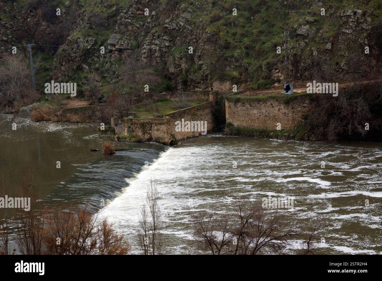Fiume con diga e argini di pietra. Fiume urbano, gestione dell'acqua, senso di flusso, elementi architettonici e ingegneristici, elemento idrico Foto Stock