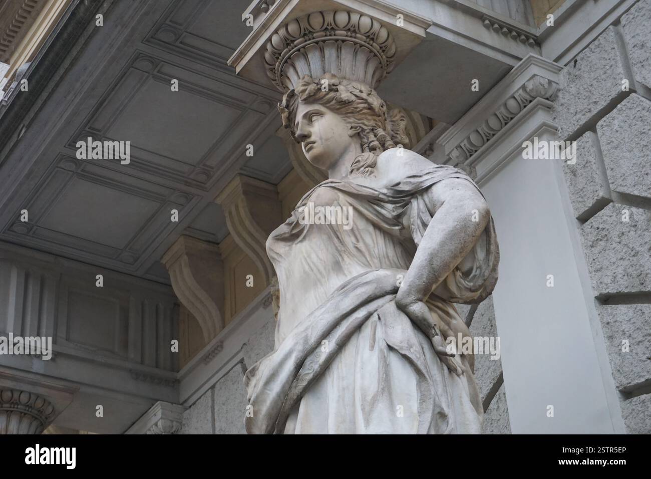 La statua di una bella donna abbellisce la colonna o il pilastro sulla facciata ornata dell'ingresso di un edificio storico di Budapest, Ungheria Foto Stock