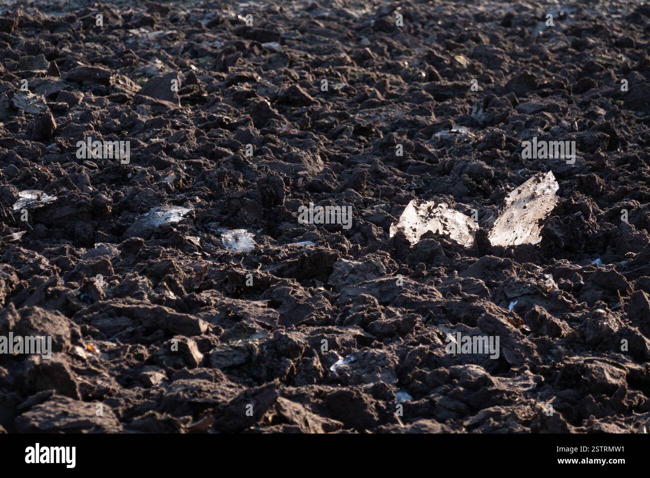 Campo, appena arato, in inverno, pezzi di ghiaccio che sporgono dal suolo Foto Stock