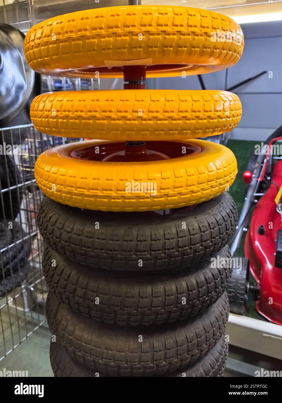Una vivace disposizione di ruote giocattolo in un'officina, con ruote gialle luminose sopra quelle nere robuste, che mostrano creatività e divertimento. Perfetto per me Foto Stock