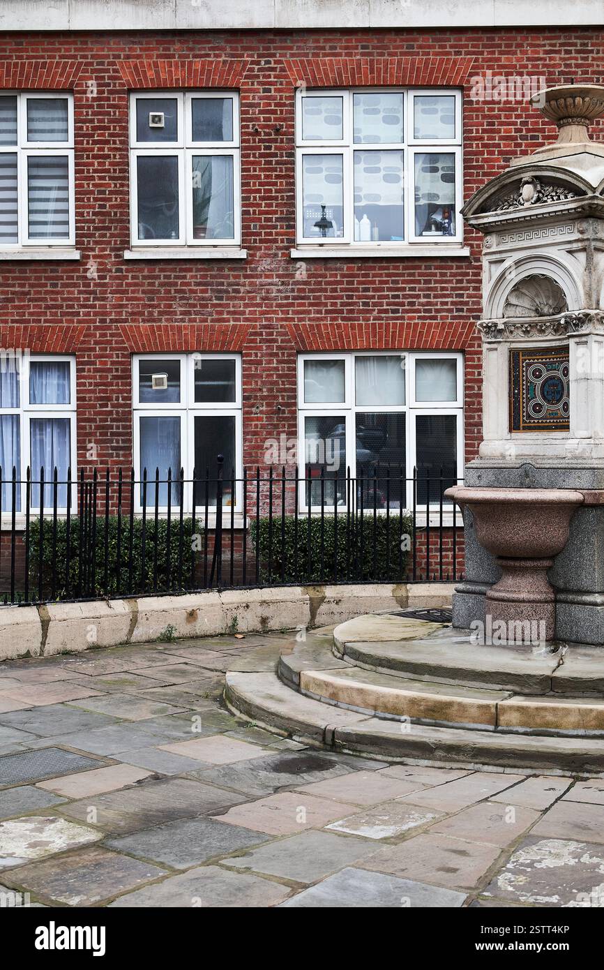 9 febbraio 2025 - Londra Regno Unito: Memorial Fountain sulla strada di fronte all'edificio in mattoni rossi Foto Stock