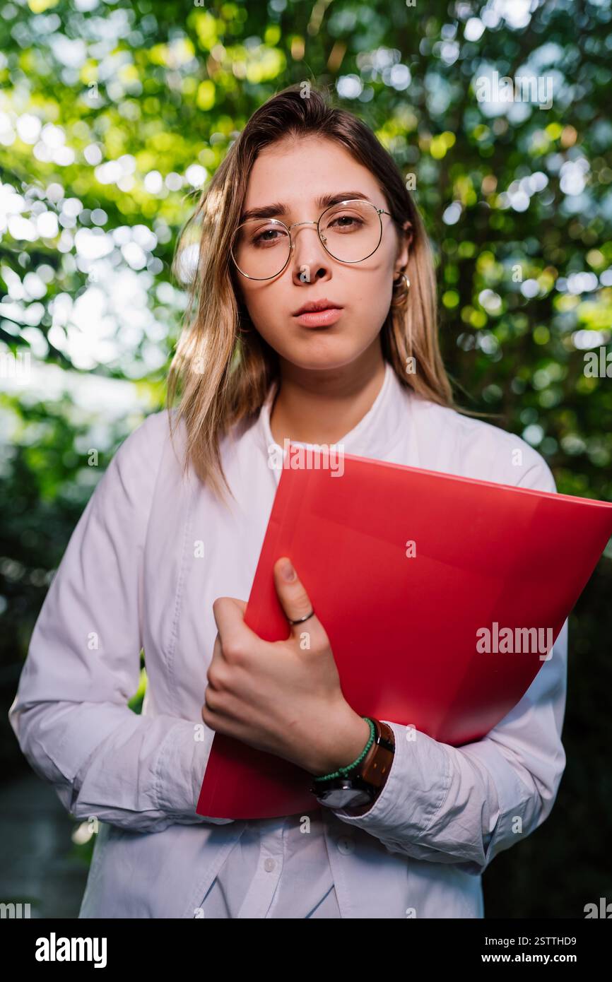 Giovane ingegnere agricolo che lavora in serra. Giovane scienziata femminile che guarda la macchina fotografica Foto Stock